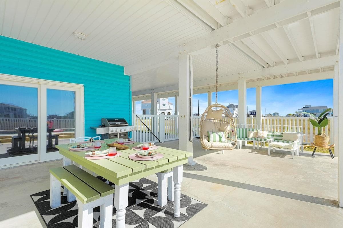 Outdoor dining table and one of the two outdoor sectionals overlooking the swimming pool and backyard. Sliding glass doors open up to the half bath, game and bunk room